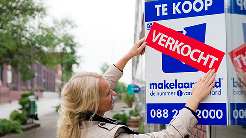 vrouw bord makelaar koopwoning